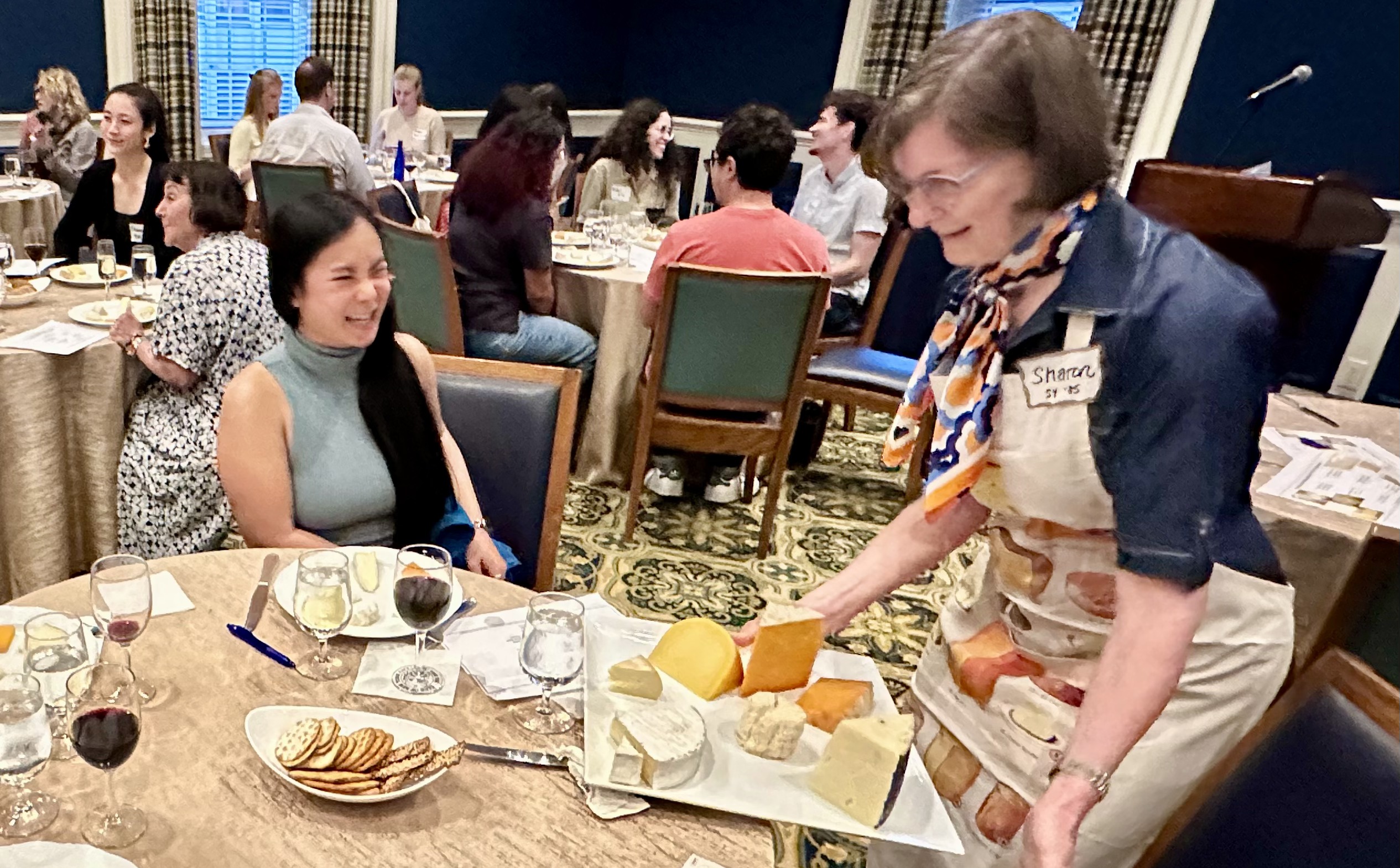 Sharon Ruwart presenting a cheese board to a student